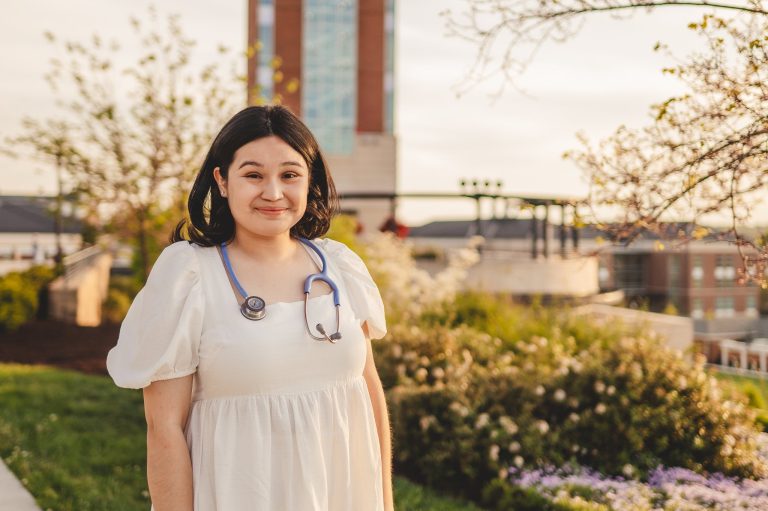 A nursing graduate student poses in front of the Freedom Tower at Liberty University