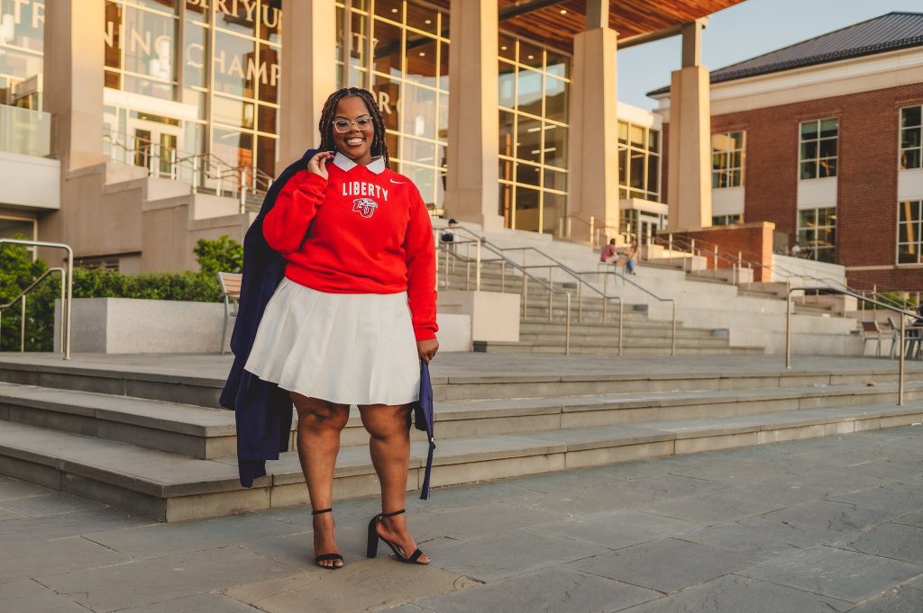 A Liberty University graduate stands outside Montview Student Union