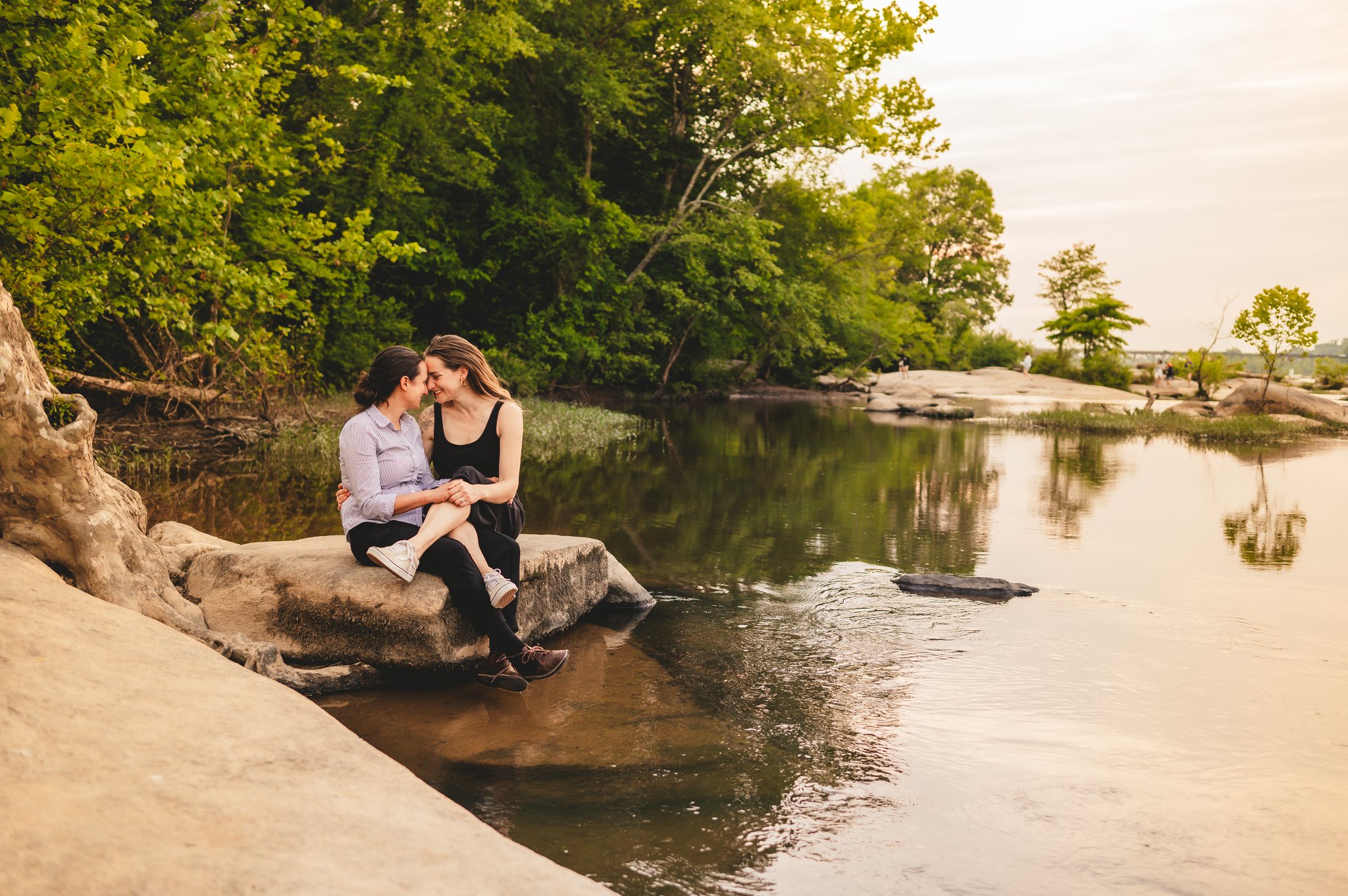 Couple pose on the James River with champagne