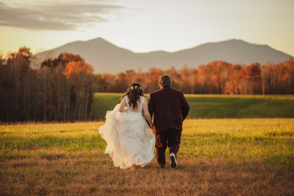 Bride and Groom running away towards the Blue Ridge Mountains at Sunset