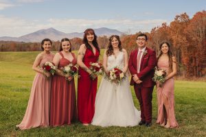Emily poses with her bridal party in front of the peaks of otter in the fall