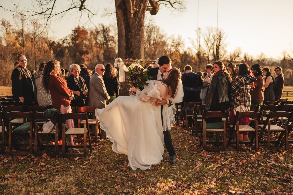 Couple dips at the end of the wedding aisle