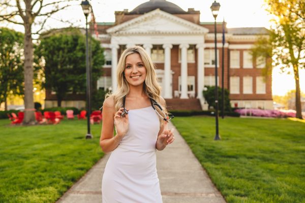 A blonde nursing student at University of Lynchburg poses on the dell.